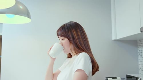 Smiling Woman Enjoying a Hot Drink at Home