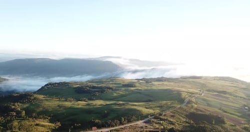 Drone footage of a beautiful landscape near a canyon and clouds.