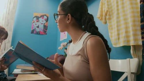 Two Young Women Study in Blue Room