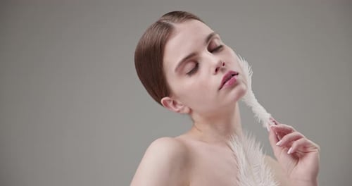 Elegant Woman with White Feather Beauty Portrait