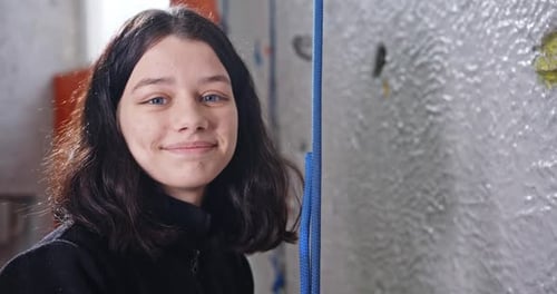 Smiling Woman Near an Indoor Climbing Wall