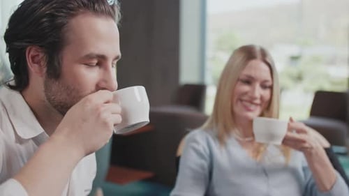 Portrait Happy Couple with a Smartphone in a Cafe Drinking Coffee Talking Discussing Smiling Sitting