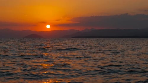 Dramatic Orange Nightfall Over Calm Lake
