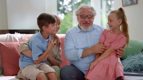 Grandparents with grandchildren sitting together on couch indoors