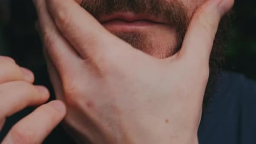 Man Touching and Grooming His Beard Close Up