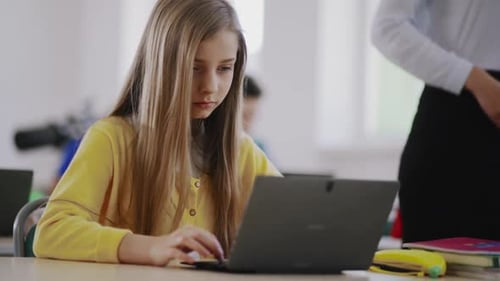 A Student Actively Engaged in Online Learning While Seated at Her School Desk with a Laptop