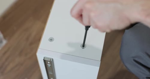 Assembling Furniture with Screwdriver for Home Improvement Project