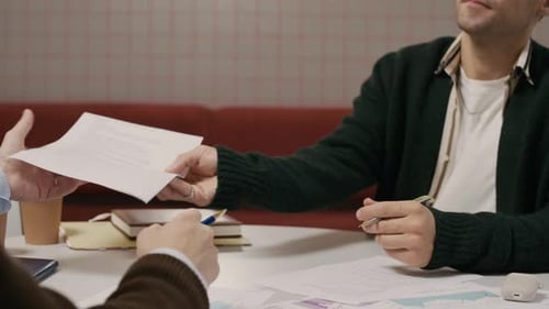 Business Meeting: Two Men Discuss Documents at Table