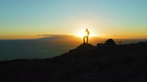 Hiking Man in Mountains Watching Sunset and Horizon Over Beautiful Ocean Landscape
