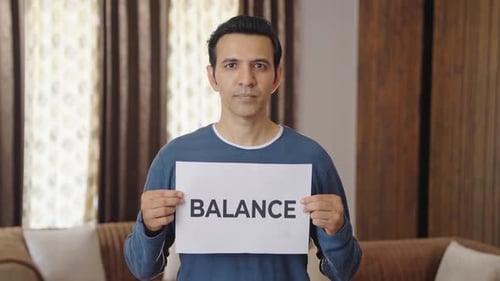 Indischer Mann hält BALANCE-Banner