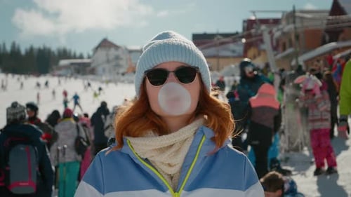 Woman Blows Gum Bubble on Snowy Ski Resort