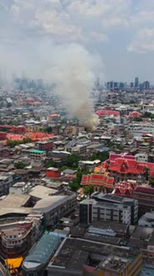 Dense Plumes of Smoke Rising Over Bangkok's Bustling Cityscape Obscuring the Cityscape Near the