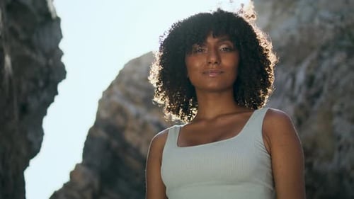 Woman Posing Naturally in Rocky Beach Sunlight
