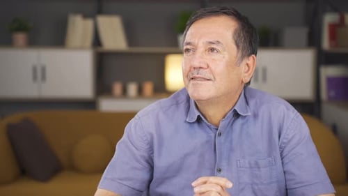 Mature Man in Blue Shirt Contemplating Thoughtfully