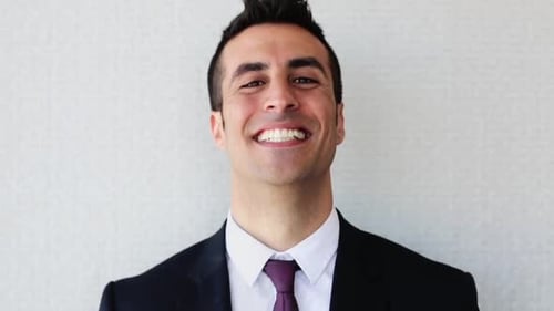 Hombre seguro de sí mismo en traje tocando el cabello