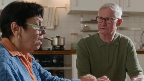 Senior Couple Reviews Finances Together in Bright Kitchen