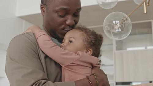 Father Holds Child Giving Affectionate Kiss
