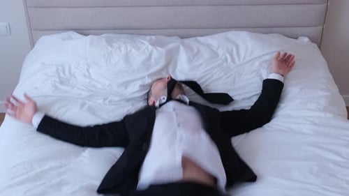 Tired Young Businessman in Suit Lying on Bed in Hotel Just Arrived Business Trip