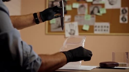 Closeup Detective's Office Middleaged Investigator in Shirt and Tie Sitting Desk Examining Evidence