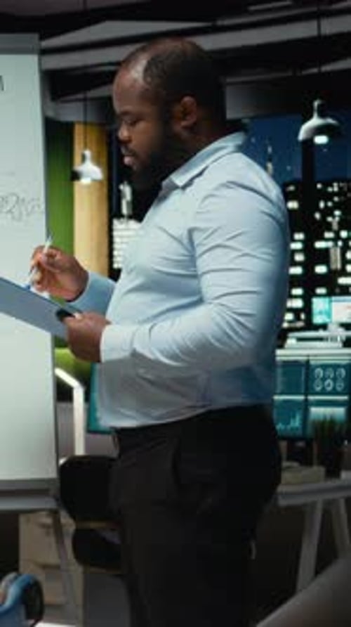 Vertical Video Male Advisor Drawing Candlestick Charts on a White Board to Review Reports