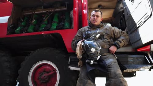 Firefighter in Protective Clothing on Fire Truck