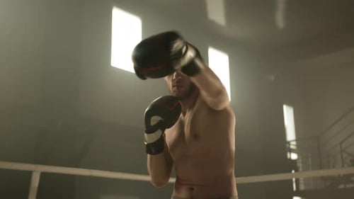 Medium Shot of Boxer with Naked Torso Practicing in Shadow Boxing in Gym