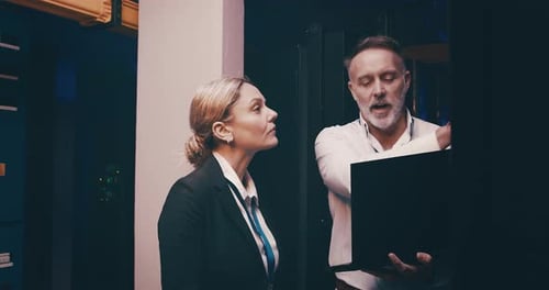 People Discussing Network Systems in Server Room