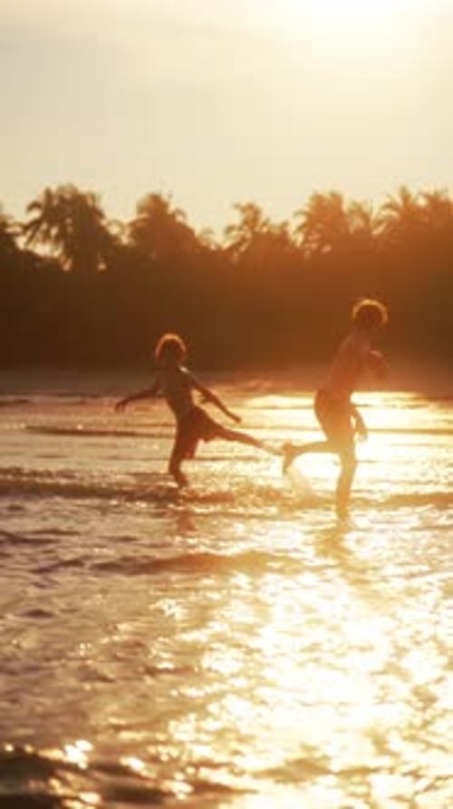 Children Enjoying Shallow Sea Waves Splashing With Bare Feet