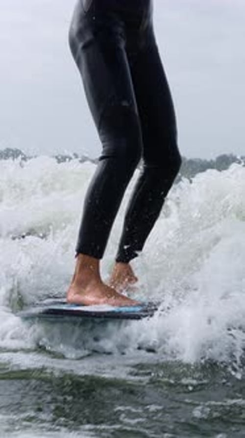 Wake Surfer Rides Wave with Bare Feet, Wetsuit