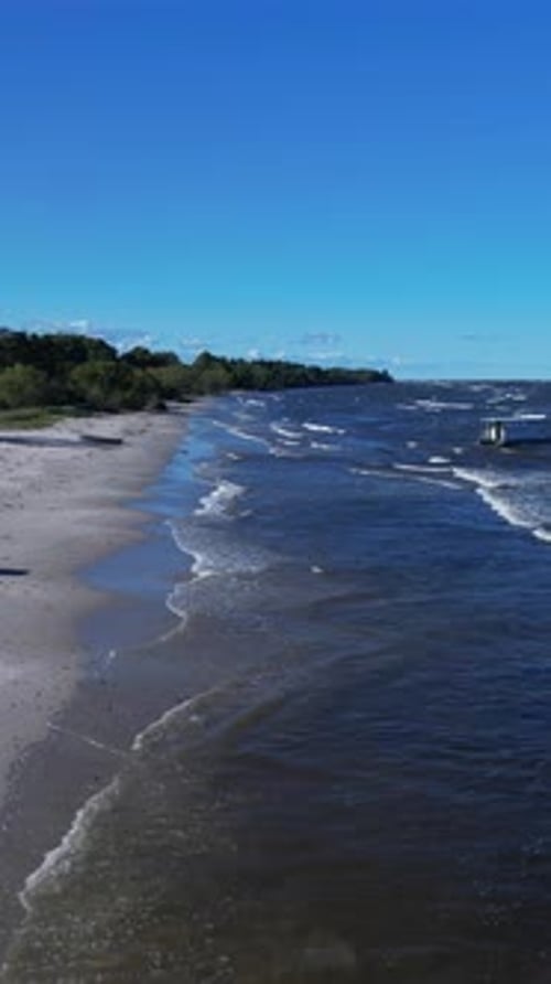 A beach with boats on the water and a sandy shore