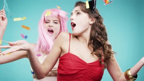 Women, friends and dancing for celebration, party and confetti against a blue studio background