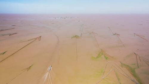 Aerial drone view of Tonle Sap. Fishing boat passing arrow headed fish traps heading to the horizon