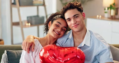 Loving Young Couple Poses Together with Heart Balloon