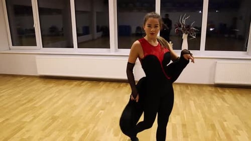 Woman Dancing in Studio Wearing Black and Red Outfit