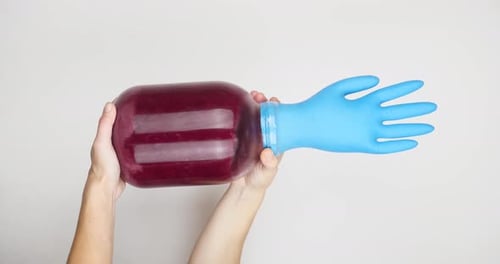 Fermentation du vin rouge à la maison avec un gant en caoutchouc sur un bocal