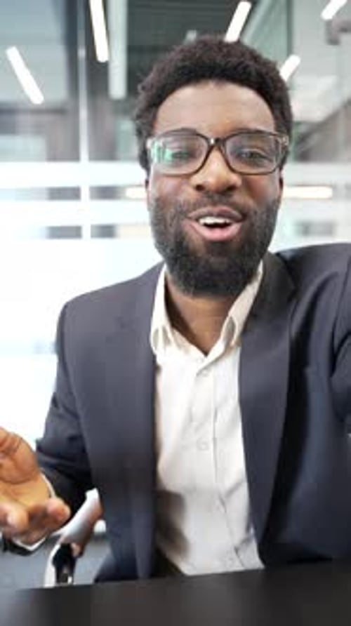 Smiling Young Man in Suit Talking in Office