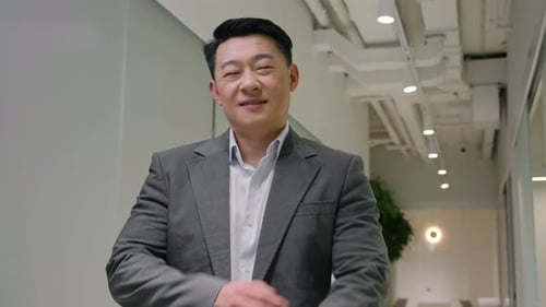 Confident Adult Smiling in Modern Office Hallway