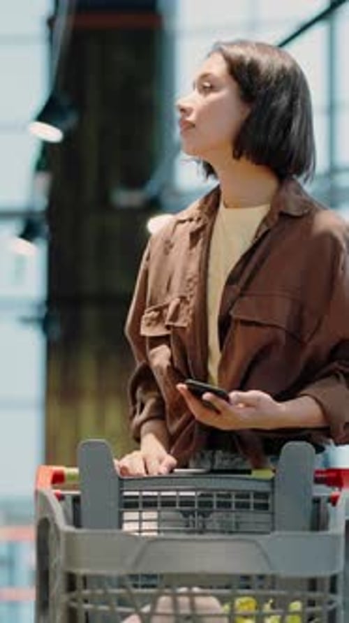 Woman Shopping and Using Her Phone in Store