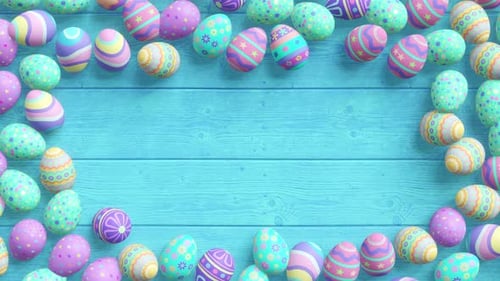 Patterned Easter eggs form a colourful frame on a turquoise wooden plank background.