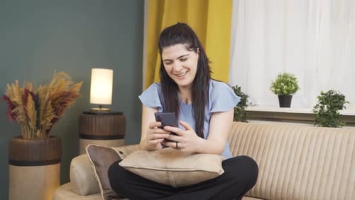 Woman laughing at phone message.