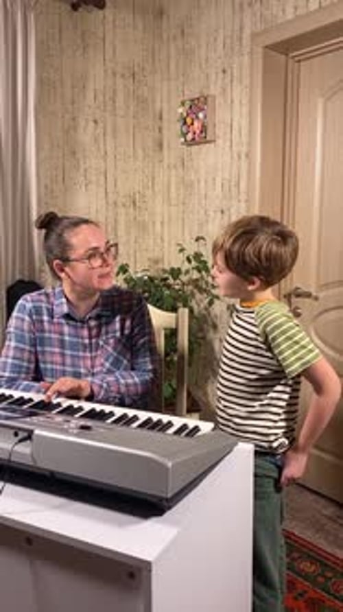 Woman Teaches Child Piano at Home