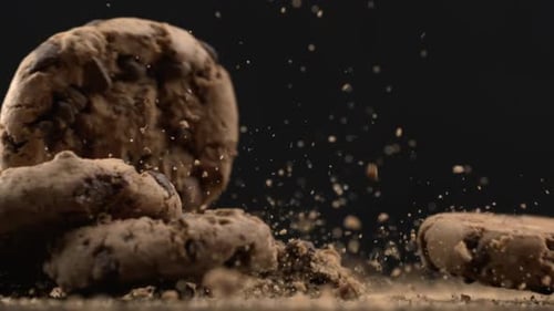 Many Chocolate chip cookies falling in super slow motion at 1000 fps with crumbs flying