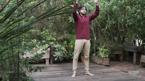 Focused caucasian man practicing yoga meditation on terrace in nature, copy space, slow motion