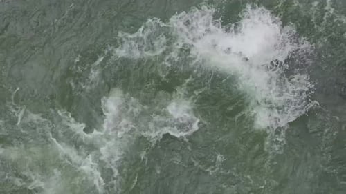 Strong river current splashing against under surface rocks. High Angle.