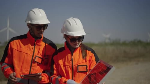 Engineers work at windmill farm.