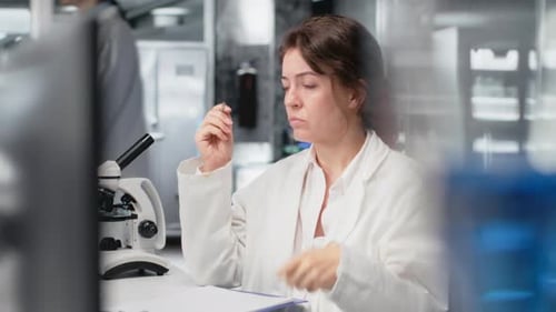 Woman Scientist Writing Notes in a Laboratory Setting