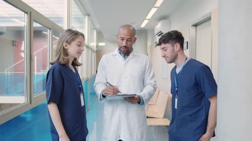 Medical Team Discussing Patient Information in Hospital Corridor