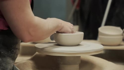 the Hands of an Adult Woman Who Handles a Ceramic Plate on a Rotating Circle