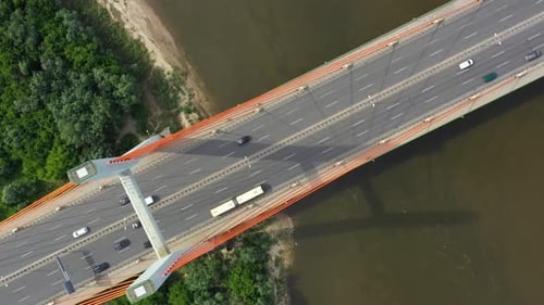 City car moving at highway bridge on background smooth river surface drone view
