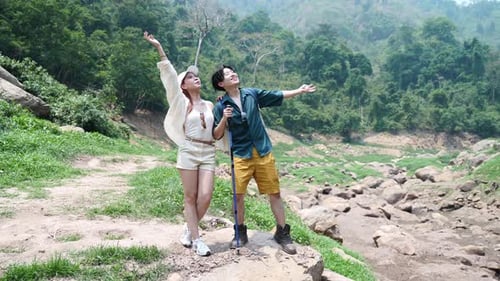 Adventurous Couple Hiking in Lush Mountainous Nature